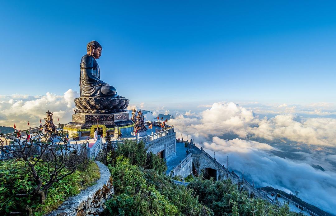 Majestic Buddha statue on a mountaintop, surrounded by clouds in Vietnam