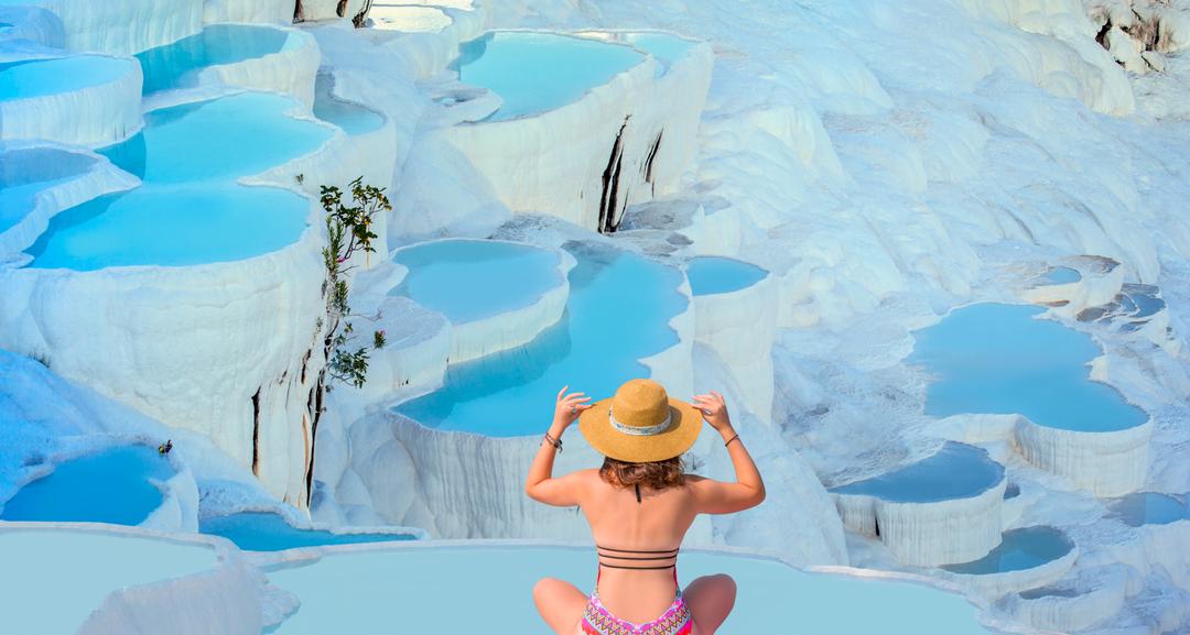 Young girl looking at travertine pools and terraces in Pamukkale - Young girl sunbathing and sitting front travertine pools - Cotton castle in southwestern Turkey